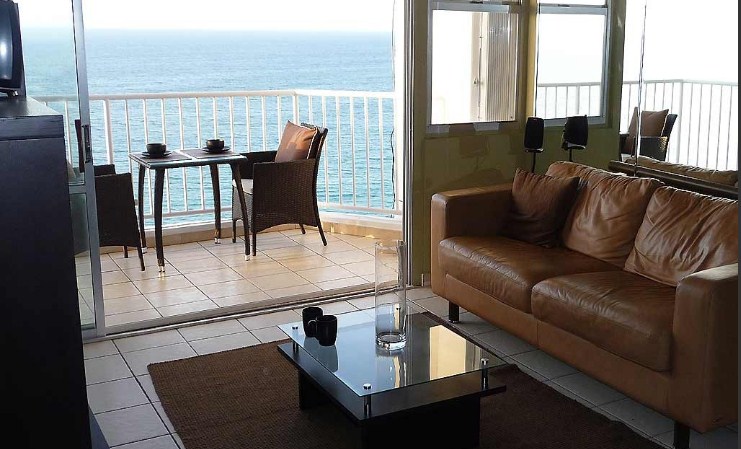 Living room and balcony. Leather sofa doubles as sofa-bed.