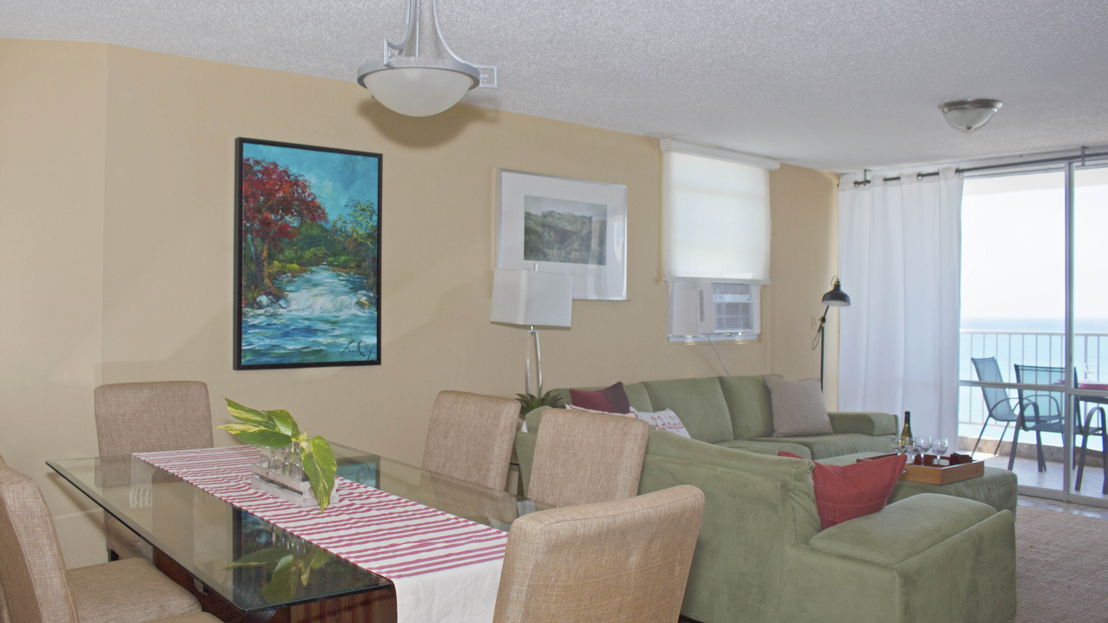 View of dining and living rooms. Balcony on the far right.